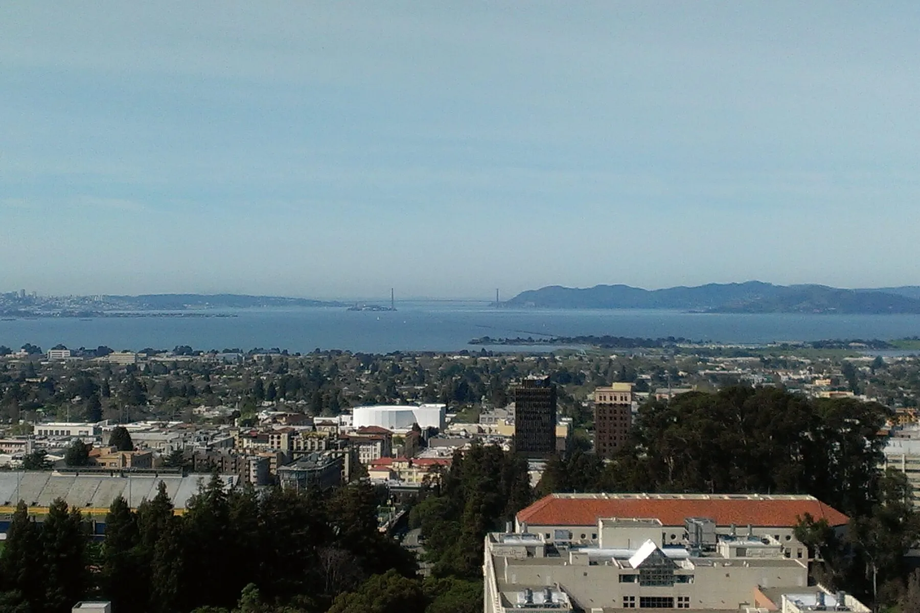Downtown Berkeley seen from above, with San Francisco Bay and the bridge beyond.